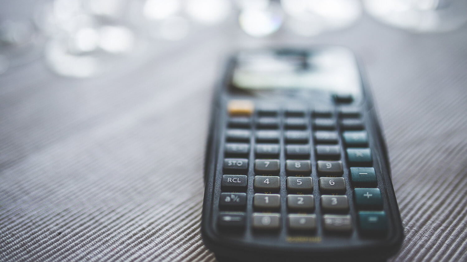 Ein Taschenrechner wird unscharf abgebildet. Am oberen Ende ist diffuses Licht.